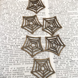 May include: Six bronze-colored spider web charms. These decorative charms are ideal for jewelry making or craft projects. Each charm has a detailed web design and a small loop for attaching to other items.