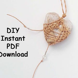 May include: A heart-shaped stone wrapped in tan macrame cord with a knotted design, featuring small clear beads on the attached string. The text DIY Instant PDF Download is printed in black on the left side of the image.