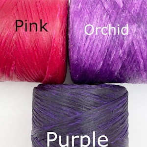 May include: Three spools of raffia ribbon in pink, orchid, and purple. The spools are labeled with the colors "Pink", "Orchid", and "Purple".