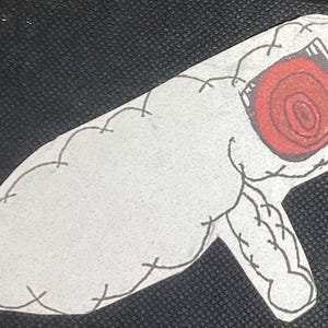 K&ouml;nnte beinhalten: Ein wei&szlig;es, gen&auml;htes, cartoonartiges Objekt mit einem roten, kreisf&ouml;rmigen, augenartigen Design. Das Objekt ist geformt wie ein langes, d&uuml;nnes Rohr mit einem abgerundeten Ende.
