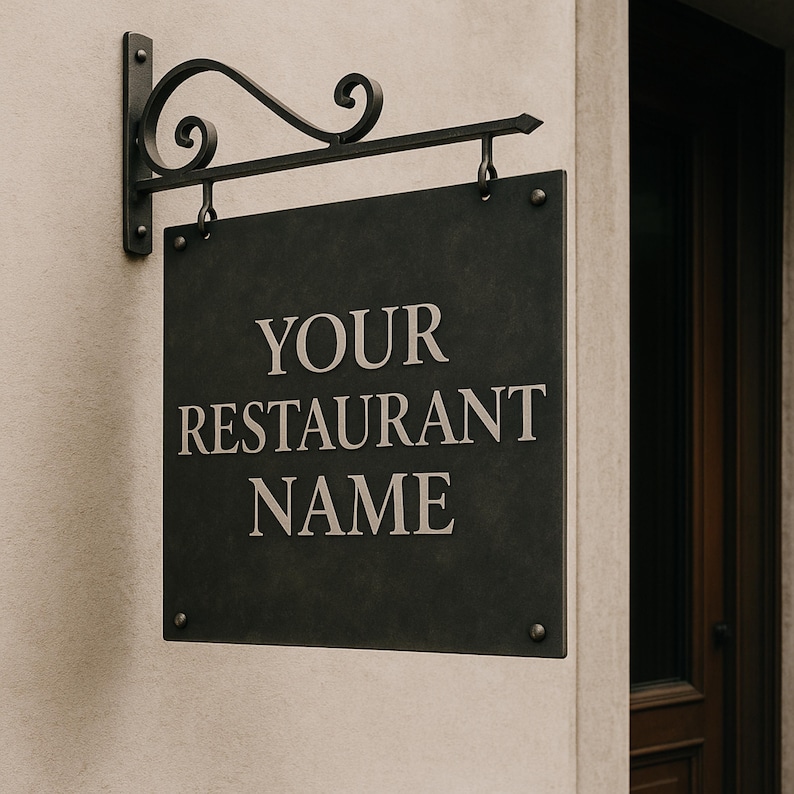 May include: A dark gray, square restaurant sign with the text "YOUR RESTAURANT NAME" in a serif font. The sign hangs from a decorative black metal bracket attached to a beige wall. The bracket has a scroll design.
