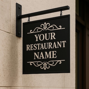 May include: Black rectangular restaurant sign with the text "YOUR RESTAURANT NAME" in white, hanging from a black metal bracket. The sign has decorative scrollwork at the top and bottom.