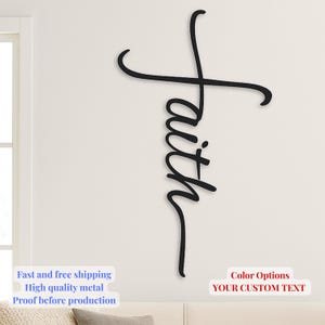 Könnte beinhalten: Ein schwarzes Metall-Wandkunstwerk, das "faith" in einer kursiven Schriftart schreibt, wobei das Kreuz des "t" eine Kreuzform bildet. Das Kunstwerk ist an einer weißen Wand befestigt. Das Bild enthält auch den Text "Color Options" und "YOUR CUSTOM TEXT".