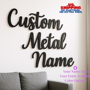 May include: Black metal sign spelling out "Custom Metal Name" in a cursive font. The sign is mounted on a white wall above a gray sofa. Text in the image reads "Your Name Sign, Your Fonts Available, Color Options."