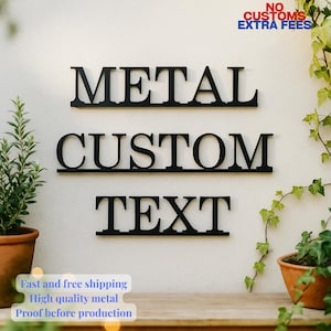 Op de afbeelding: Zwarte metalen muurkunst met de woorden "METAL CUSTOM TEXT" in een vetgedrukte, schreefloze lettertype. De woorden zijn op een witte muur gemonteerd, met groen en een terracotta pot op de achtergrond. De tekst "NO CUSTOMS EXTRA FEES" staat rechtsboven.