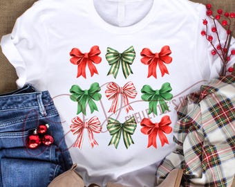 Op de afbeelding: Wit T-shirt met een ontwerp van negen rode, groene en gouden strikken. De strikken zijn gerangschikt in drie rijen van drie.