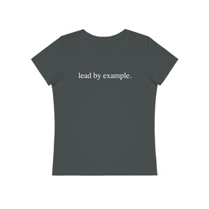 Peut inclure: Un t-shirt gris foncé avec le texte "lead by example." imprimé en blanc.