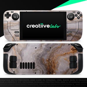 May include: A gaming console skin with a marble design. The skin covers the front and back of the console, featuring a pattern of gray, brown, and white swirls. The screen displays the "creatiivelabs" logo in green. The console has black buttons and controls.