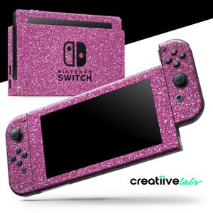 Può includere: Console e controller Nintendo Switch con glitter rosa e il testo "Nintendo Switch" sulla console.