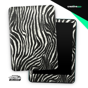 May include: A black tablet with a zebra print case, open to reveal the screen. The case is black and white with a zebra stripe pattern. The tablet has a black screen and a teal border.