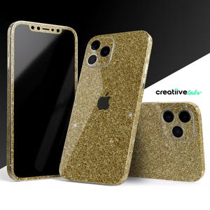 May include: Gold glitter iPhone cases and screen protector. The cases feature a sparkly, textured surface and a cutout for the Apple logo. The screen protector is black. The brand name "creatiivelabs" is visible.