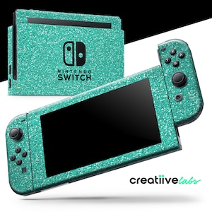 May include: A teal glitter-covered Nintendo Switch console and controllers. The console has the Nintendo Switch logo and text. The controllers and console are teal with a glitter effect. The screen is black. The brand name "creatiive labs" is in the bottom right corner.