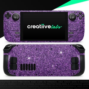May include: A purple glitter skin for a handheld gaming device. The device has a black screen with the text "creatiivelabs" in white and green. The skin covers the front and back of the device, with black buttons and controls. The device is designed for gaming.