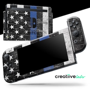 May include: A Nintendo Switch console and controllers with a distressed American flag design. The design features white stars on a black background, with a blue stripe and white wood grain. The Nintendo Switch logo is visible.
