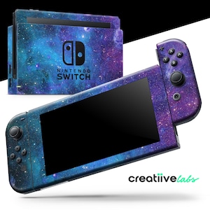 May include: A Nintendo Switch console and controllers with a galaxy-themed skin. The skin features a blue, purple, and white cosmic design. The console has the Nintendo Switch logo on the front. The image also includes the text "creatiive labs".