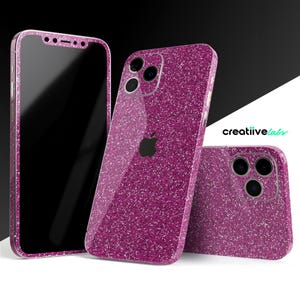 Może przedstawiać: Trzy różowe błyszczące etui na telefon do iPhone'a. Etui mają błyszczące wykończenie i przezroczyste logo Apple.