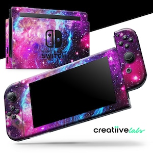 May include: Nintendo Switch console and controllers with a vibrant galaxy skin. The design features a mix of pink, purple, and blue hues, with a starry pattern. The console and controllers are displayed against a white background.