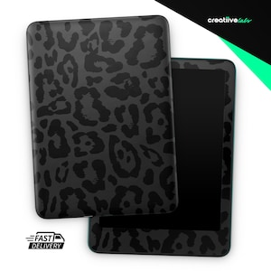 May include: A black tablet case and tablet with a dark gray leopard print design. The tablet has a black screen and a teal border. The case is rectangular and has a matching leopard print. The words "Fast Delivery" are in the lower left corner.