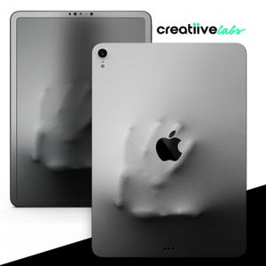 May include: A gray iPad with a textured, hand-shaped design and a black Apple logo. The iPad is in a protective case.