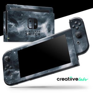 May include: A Nintendo Switch console and controllers with a nebula-themed design. The console and controllers are dark gray with white and black swirling patterns. The Nintendo Switch logo is visible on the console.