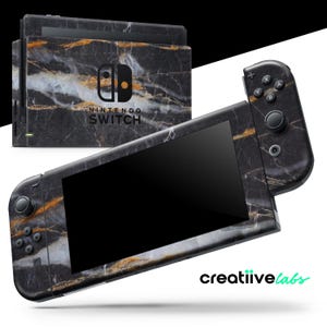 May include: Nintendo Switch console and controllers with a black marble design. The console and controllers have a black, white, and gold veined pattern. The Nintendo Switch logo is visible on the console. The brand name "creatiive labs" is in the bottom right corner.