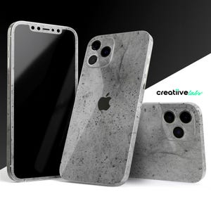 May include: Three iPhone cases with a gray concrete pattern. The cases are designed to fit the iPhone 13 Pro Max. The cases have a textured surface and a subtle gray color.