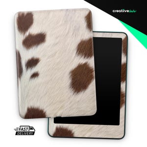 May include: Tablet case with a cowhide pattern. The case features a white background with irregular brown spots. The tablet screen is black. The words "FAST DELIVERY" are printed on the bottom left.