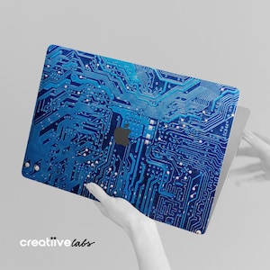 May include: A blue laptop skin with a circuit board design. The skin has a metallic sheen and features a white Apple logo.