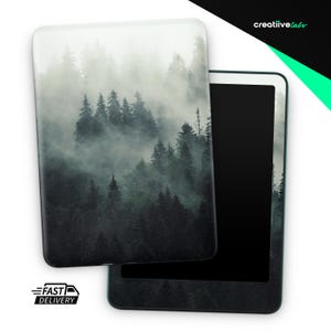 May include: A tablet with a forest scene cover. The cover features a misty forest with tall, dark green trees. The tablet's screen is black, and the frame is a light teal color. The words "creatiivelabs" are in the upper right corner.