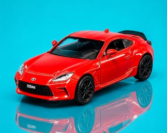 Miniatura MSZ Toyota GR86 em escala 1:36, cor vermelha metálica, com portas que abrem e mecanismo de fricção.