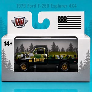 May include: A 1979 Ford F-250 Explorer 4x4 die-cast truck in a white display box. The truck features a black, green, and white camouflage pattern with the word LIBERTY in yellow on the side. The box includes an M2 Machines logo, a US flag, and 14+ text.