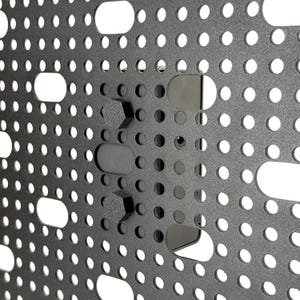 May include: Close-up of a dark gray metal panel with a grid of small, evenly spaced holes and larger, oblong cutouts. Several black, geometric-shaped mounting components are attached to the panel, creating a textured surface.