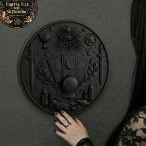 May include: A black, circular wall hanging with embossed tarot-themed imagery, including cards, a crystal ball, and swords. The design features an all-seeing eye and a crescent moon. The text "DIGITAL FILE FOR 3D PRINTING" is in a circular graphic in the upper left.