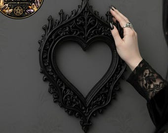 May include: A black heart-shaped frame with ornate detailing hangs on a dark gray wall. The frame has a decorative, gothic design. A circular graphic with text that reads "DIGITAL FILE FOR 3D PRINTING" is in the upper left corner.