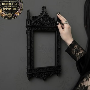 May include: A black gothic-style picture frame with ornate detailing is mounted on a gray wall. The frame is empty, and the design includes pointed arches and decorative elements. A circular graphic with text "DIGITAL FILE FOR 3D PRINTING" is in the upper left.
