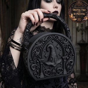 Puede incluir: Bolso negro y redondo con detalles góticos ornamentados. El bolso presenta un diseño de sombrero de bruja y el texto "DIGITAL FILE FOR 3D PRINTING" en un emblema circular. El asa también está intrincadamente tallada.