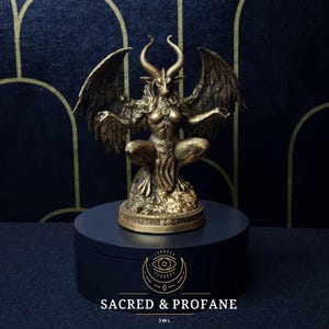 May include: A gold-coloured statue of a winged demon with horns and a human-like body. The statue is sitting on a black circular base with the text "SACRED & PROFANE" and "JWL" printed on it.