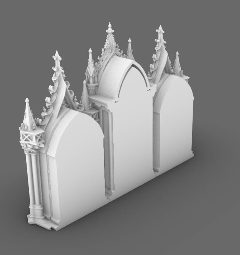 May include: A white, 3D-printed architectural model of a gothic cathedral facade. The model features arched doorways, ornate spires, and detailed decorative elements. The design is symmetrical and stands on a gray surface.