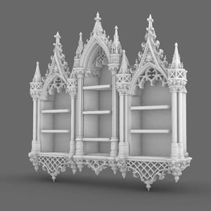 May include: A white, ornate bookshelf with a gothic architectural design. The bookshelf features three sections, each with shelves for storage. The design includes pointed arches, decorative spires, and intricate detailing, creating a vintage aesthetic.