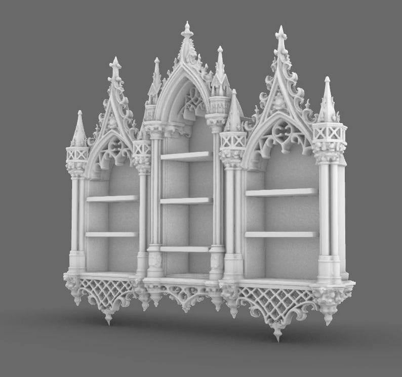 May include: A white, ornate bookshelf with a gothic architectural design. The bookshelf features three sections, each with shelves for storage. The design includes pointed arches, decorative spires, and intricate detailing, creating a vintage aesthetic.