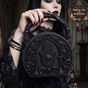 Puede incluir: Bolso de mano negro y ornamentado con asa, con un diseño de mano de Hamsa y ojo. El bolso tiene un patrón tallado detallado y lo sostiene una persona. La imagen incluye un gráfico circular que dice "DIGITAL FILE FOR 3D PRINTING".