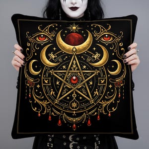 Può includere: Cuscino decorativo nero con un design occulto dorato e rosso. Il design presenta un pentagramma, lune crescenti e occhi stilizzati. Il cuscino ha un bordo nero.