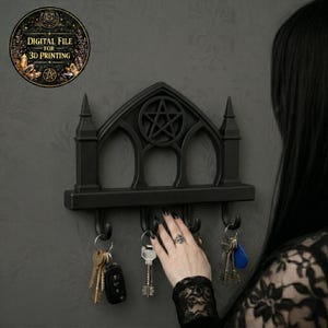May include: Black gothic key holder featuring a pentagram. The key holder has a shelf with three arched openings and four hooks for keys. The key holder is mounted on a wall. A circular graphic with the text "DIGITAL FILE FOR 3D PRINTING" is in the upper left corner.