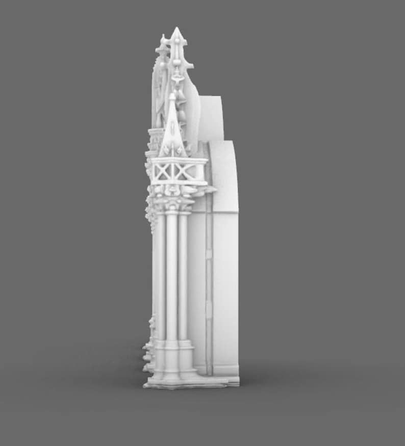 May include: A white, architectural model featuring intricate details. The design includes columns, spires, and decorative elements, showcasing a classical or gothic style. The model is set against a neutral gray background.