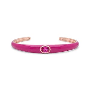 May include: A rose gold-toned cuff bracelet featuring a vibrant magenta enamel coating and a central oval-shaped magenta gemstone set in a rose gold bezel. The interior of the bracelet is stamped with the number 925, indicating sterling silver.