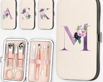 May include: A manicure set with a beige case featuring a purple floral initial. The set includes nail clippers, scissors, and other tools. Additional cases with floral initials A, S, and K are also shown.