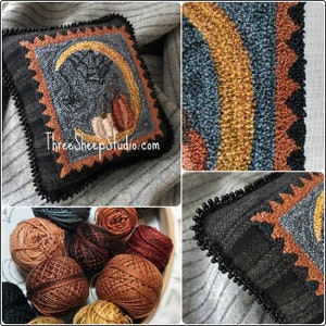 May include: A hand-stitched wool rug with a crescent moon and pumpkins design. The rug is framed with a black beaded border and has the text "ThreeSheepStudio.com" in the bottom center. The rug is surrounded by balls of yarn in various shades of brown.