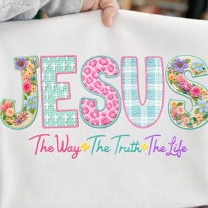 Puede incluir: Sudadera blanca con la palabra "JESUS" bordada en dise&ntilde;os coloridos, florales y estampados. Debajo de la palabra "JESUS" est&aacute; el texto bordado "The Way The Truth The Life".