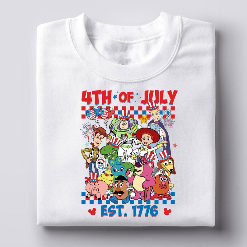 May include: White t-shirt with a graphic of the Toy Story characters wearing red, white, and blue patriotic hats. The text "4th of July Est. 1776" is printed below the characters.