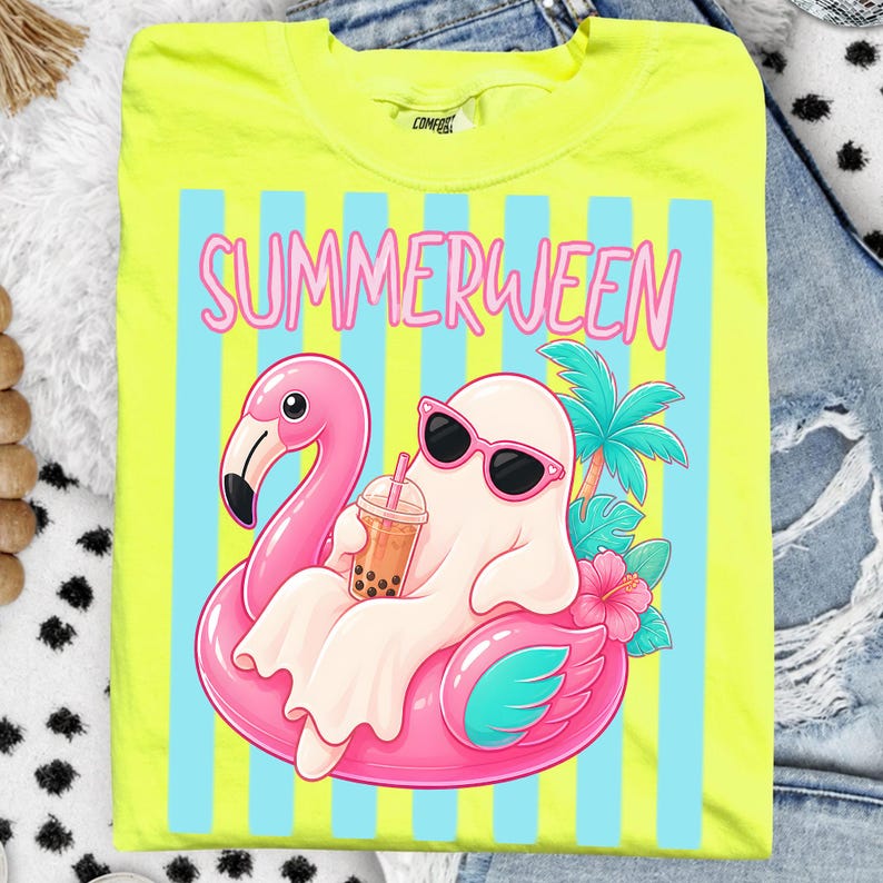 K&ouml;nnte beinhalten: Neongelbes T-Shirt mit einem Motiv eines Geistes mit Sonnenbrille, der auf einem rosa Flamingo-Schwimmring liegt und Bubble Tea trinkt. Das Shirt zeigt das Wort "SUMMERWEEN" in rosa Buchstaben &uuml;ber blauen und wei&szlig;en Streifen.